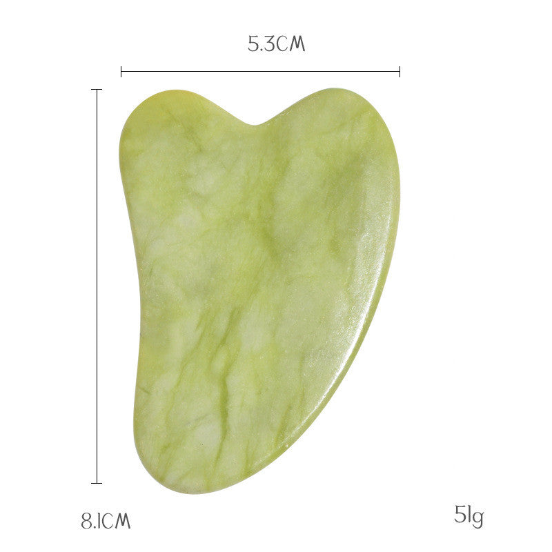 Jade gua sha stone in pale green, 8.1 cm by 5.3 cm and 51 g, heart shaped for cheek and jaw contouring