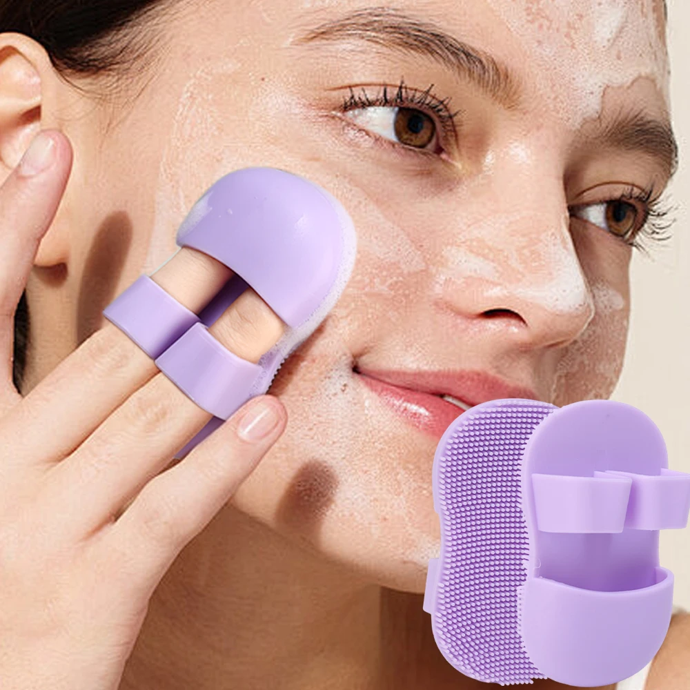 Purple silicone finger scrubber working cleanser into a lathered cheek in small circles